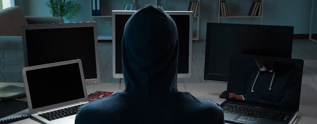 Hacker sitting in front of multiple computers