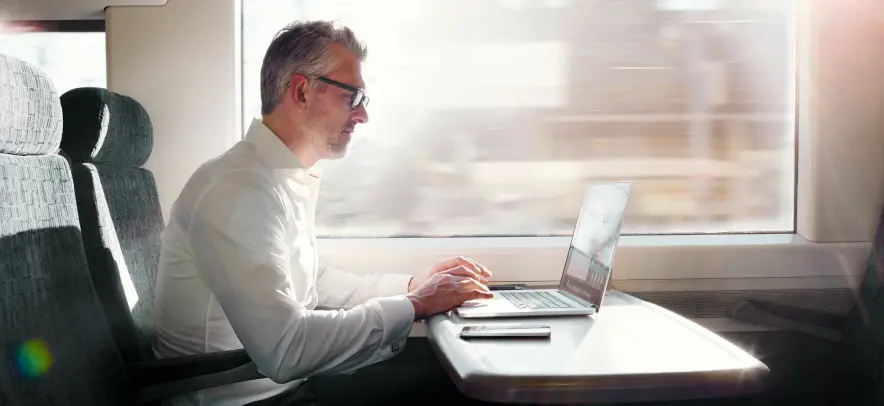 Homme travaillant sur son ordinateur dans un train