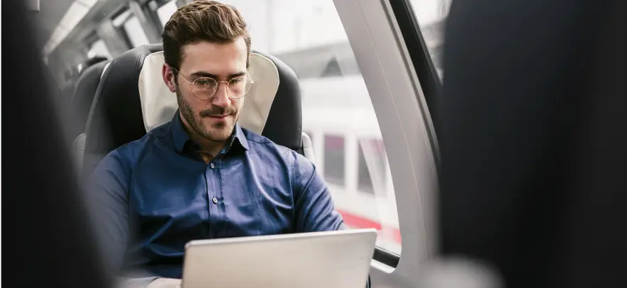Homme travaillant sur son ordinateur portable dans un train